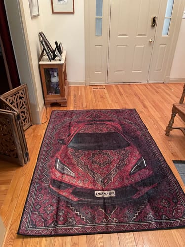Red sports car rug displayed in an entryway